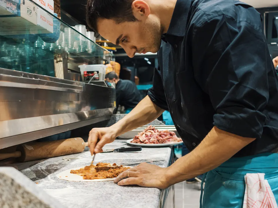 Bei Kani Kebap wird der Teig von Hand belegt